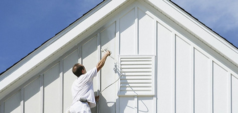 Painter applying a fresh exterior finish