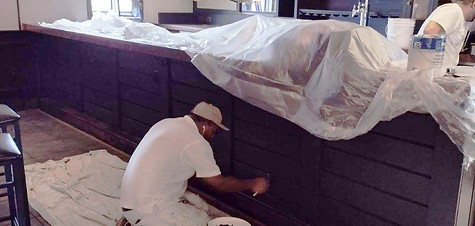 Painter working on kitchen cabinetry